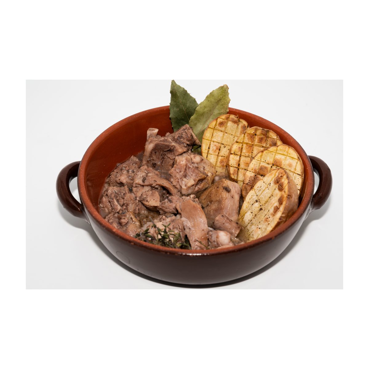 Cazuela de barro con cabrito confitado y patatas asadas